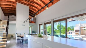 A modern kitchen with a large island, a dining area, and a view of a swimming pool. - Beautiful private villa with hot tub, A/C, private pool, WIFI, TV, terrace and pets allowed (Pazin)