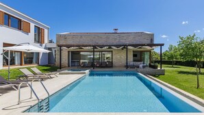 A modern house with a swimming pool, outdoor seating, and a covered patio area. - Beautiful private villa with hot tub, A/C, private pool, WIFI, TV, terrace and pets allowed (Pazin)