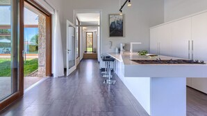 A modern kitchen with a large island, a dining area, and a view of the outdoors. - Beautiful private villa with hot tub, A/C, private pool, WIFI, TV, terrace and pets allowed (Pazin)