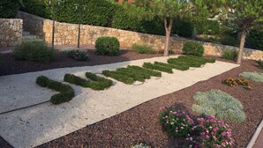 A landscaped garden with a gravel path, various shrubs, and flowering plants. - Luxurious Beach Apartment, Juan Les Pins (Antibes)