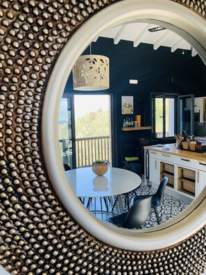 Enjoy meals in this cozy dining area with a round table, comfortable chairs, and a beautiful view of the surrounding greenery.