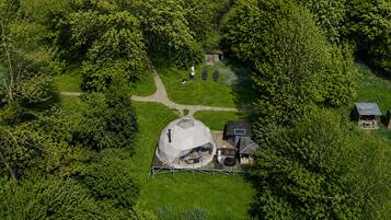 A large, dome-shaped structure with a covered seating area, surrounded by a well-maintained lawn and trees.