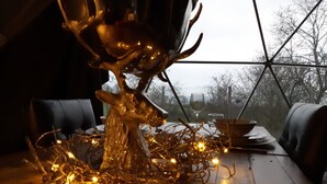 Ein Essbereich mit einem Tisch für zwei Personen, der durch eine einzigartige Glaskunst und Lichterketten akzentuiert wird.