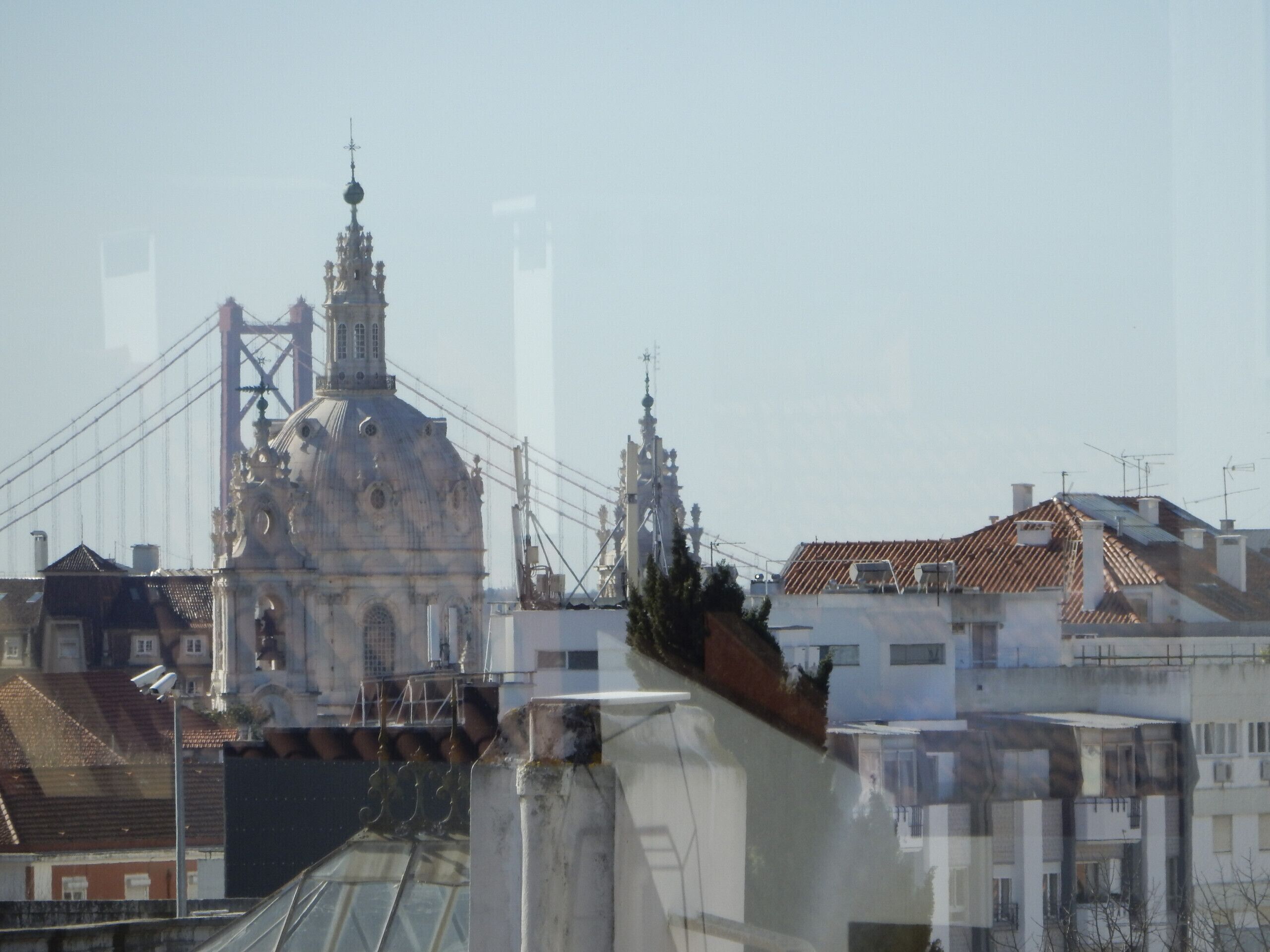 Un edificio con una grande cupola e una torre, circondato da altri edifici.