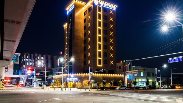 Un hotel con un letrero llamativo, varios pisos y una fachada bien iluminada.