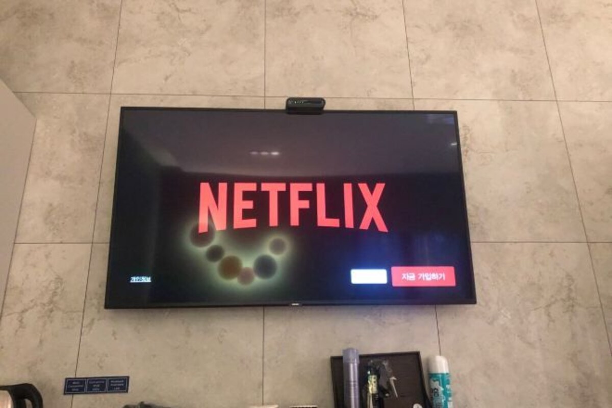 Un televisor de pantalla plana montado en una pared de azulejos mostrando el logotipo de Netflix.