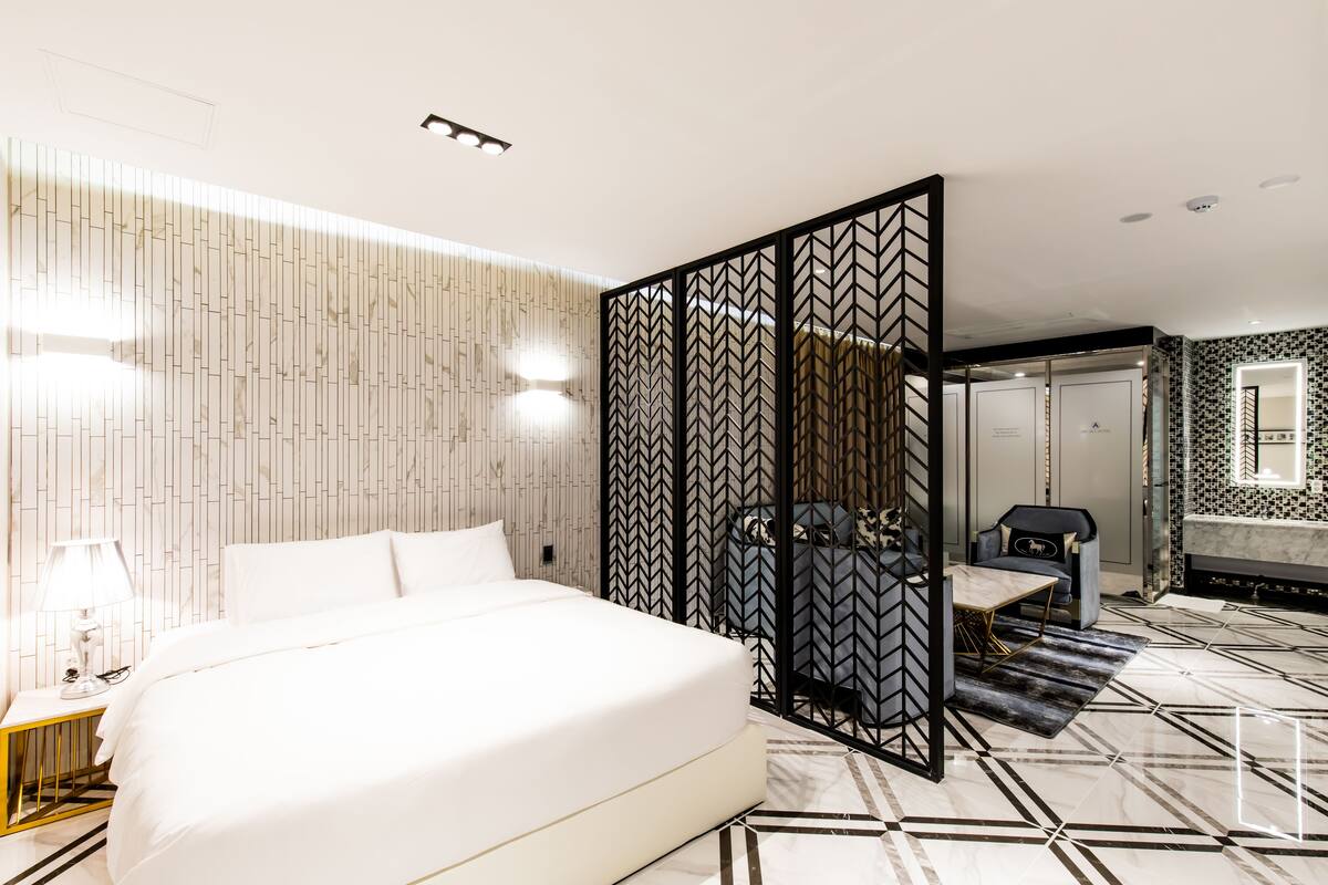 Ein modernes Hotelzimmer mit einem großen Bett, einem Schreibtisch und einer Sitzecke.