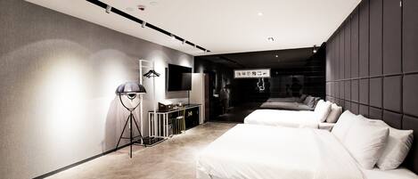A modern hotel room with two beds, a desk, and a wardrobe.