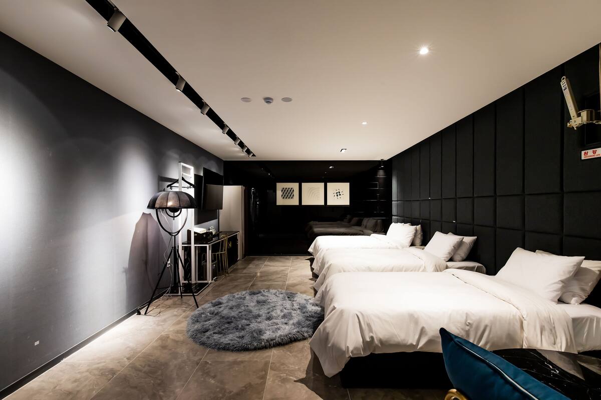 Ein modernes Hotelzimmer mit zwei Betten, einem Schreibtisch und einem großen Fenster.