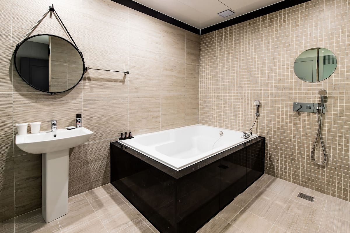 business studio suite | bathroom | combined shower/bathtub, deep-soaking bathtub, designer toiletries