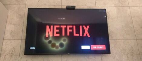A television mounted on a wall displaying the Netflix logo.
