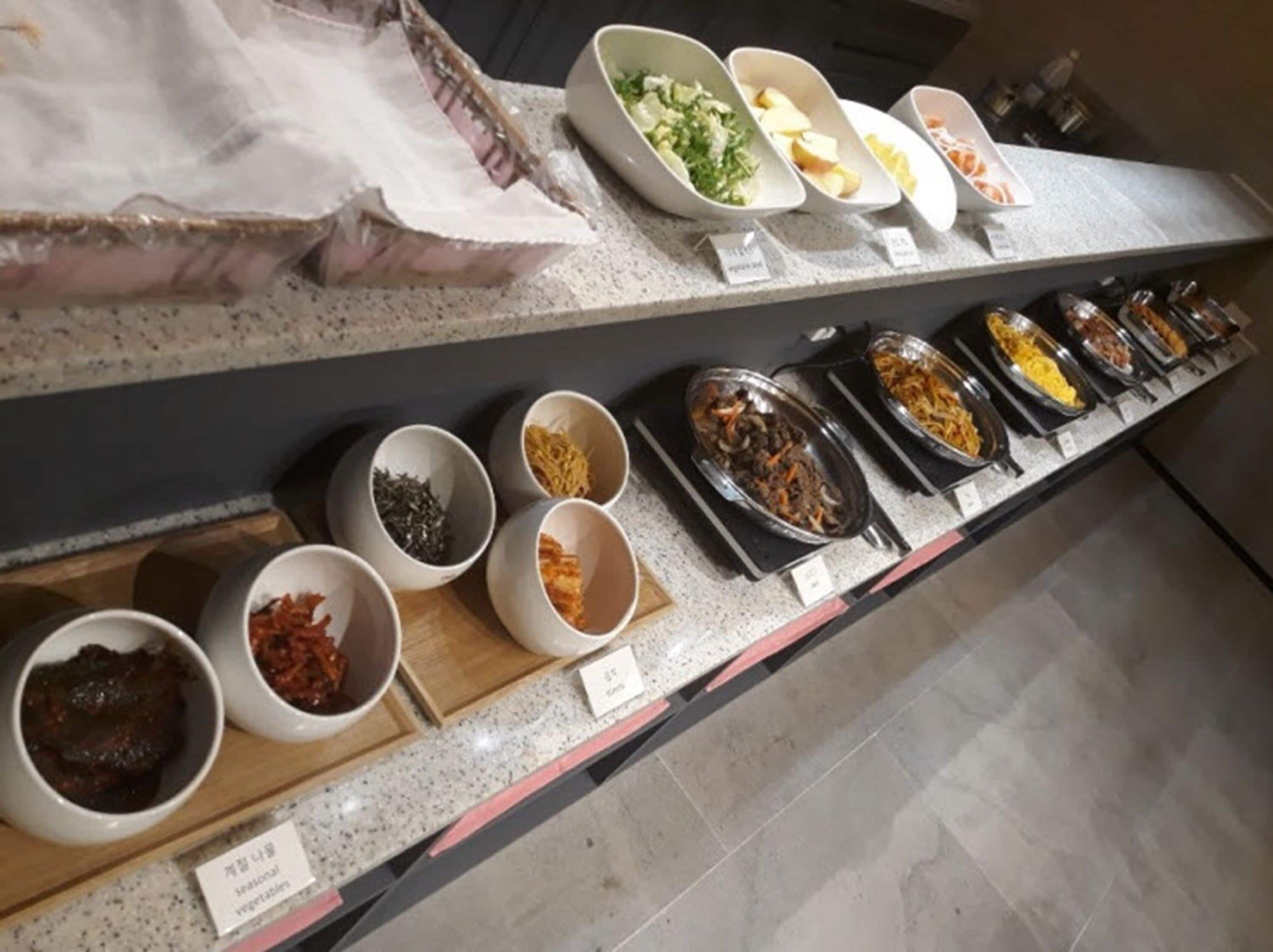 Buffet com diversos pratos e acompanhamentos.