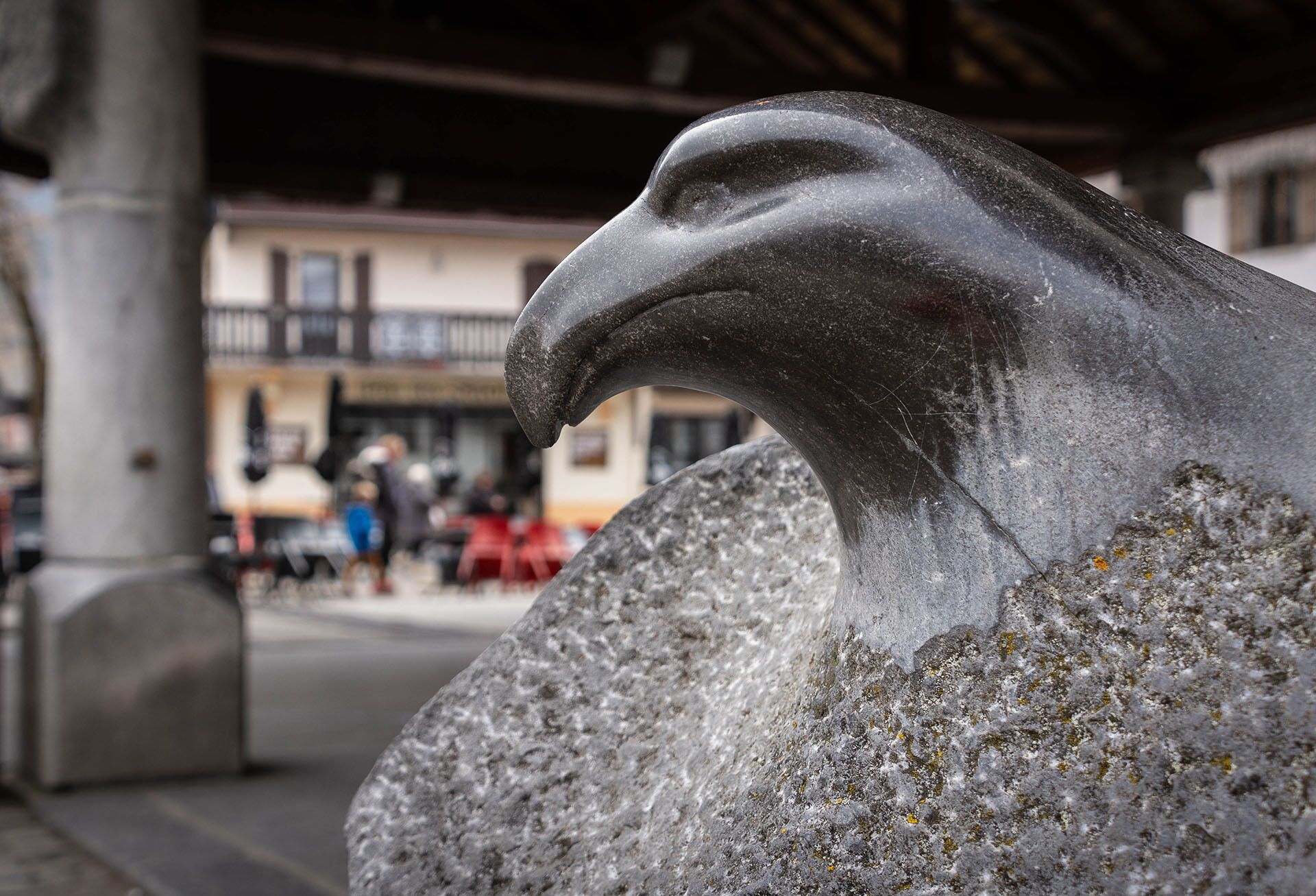 A stone eagle head sculpture in an outdoor setting.