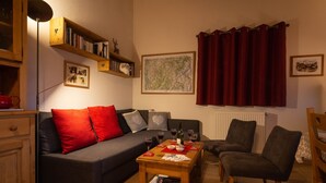 A cozy living room with a sofa, armchairs, a coffee table, and a bookshelf. - Family friendly 3-bedroom apartment in Samoens close to ski bus and amenities (Samoëns)
