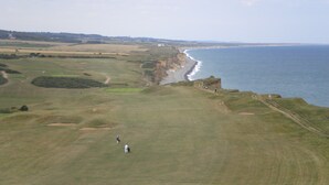 Un campo de golf costero con vistas al océano y a los acantilados.