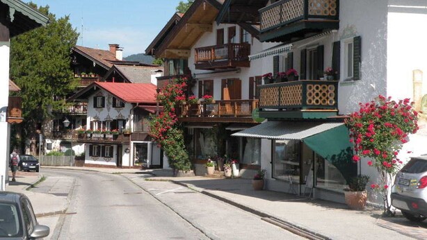 A row of traditional European-style buildings with balconies, some with flower boxes. - Apartment OG - Apartments Rosenhof (Tegernsee)