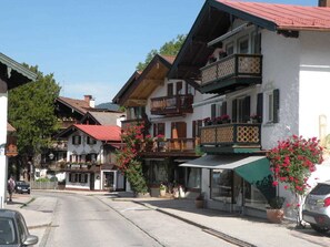 A row of traditional European-style buildings with balconies, some with flower boxes. - Apartment OG - Apartments Rosenhof (Tegernsee)