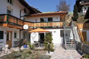A building with a balcony, outdoor seating, and a staircase.
