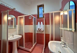 A bathroom with a glass-enclosed shower, a sink, and a mirror. - Guest House 32 (Sofia)
