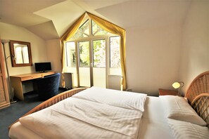 A bedroom with a bed, a desk, a chair, a television, and a window with curtains. - KIWI Apartment 3 - KIWI Apartments on Lake Dreier (Alt Schwerin)