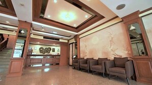 A spacious lobby with a reception desk, seating area, and a staircase. - Hua Lin Inn (Chiang Mai)