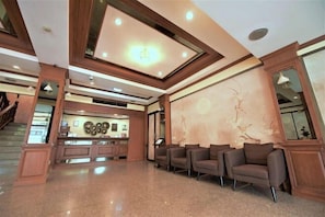 A spacious lobby with a reception desk, seating area, and a staircase. - Hua Lin Inn (Chiang Mai)