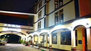 A hotel with a covered outdoor area, multiple floors, and a sign indicating it is a hotel. - Hua Lin Inn (Chiang Mai)