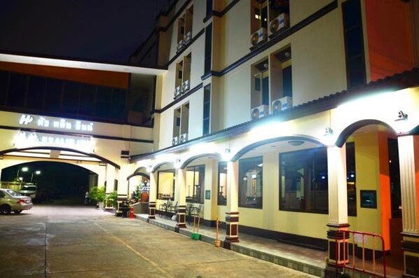 A hotel with a covered outdoor area, multiple floors, and a sign indicating it is a hotel.
