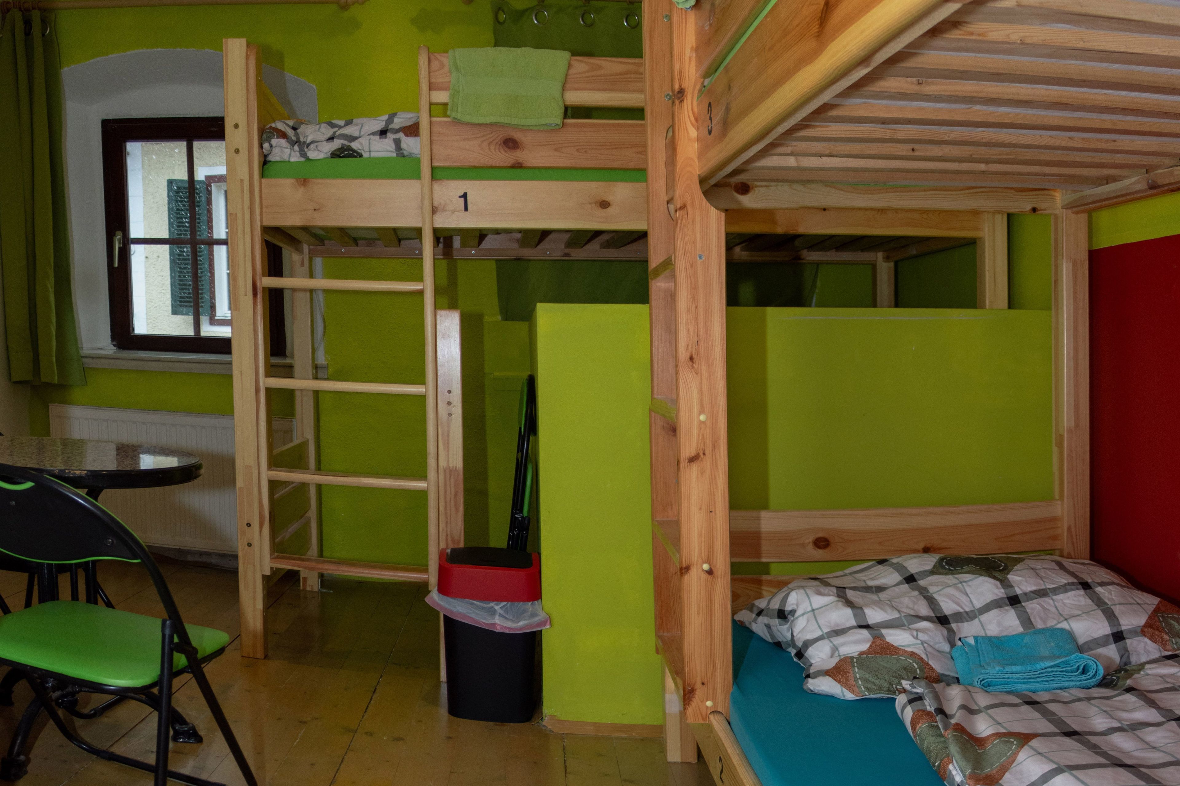 Dormitorio con literas, una ventana, un escritorio y una silla.