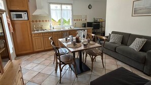 A compact living space with a dining area, kitchenette, and a sofa.