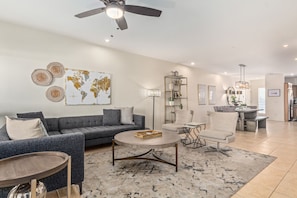 A modern living room with a grey sofa, round coffee table, and a world map artwork on the wall.