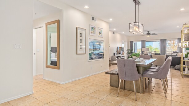 Una cocina amplia con comedor, que cuenta con un gran ventanal, decoración moderna y un ventilador de techo.
