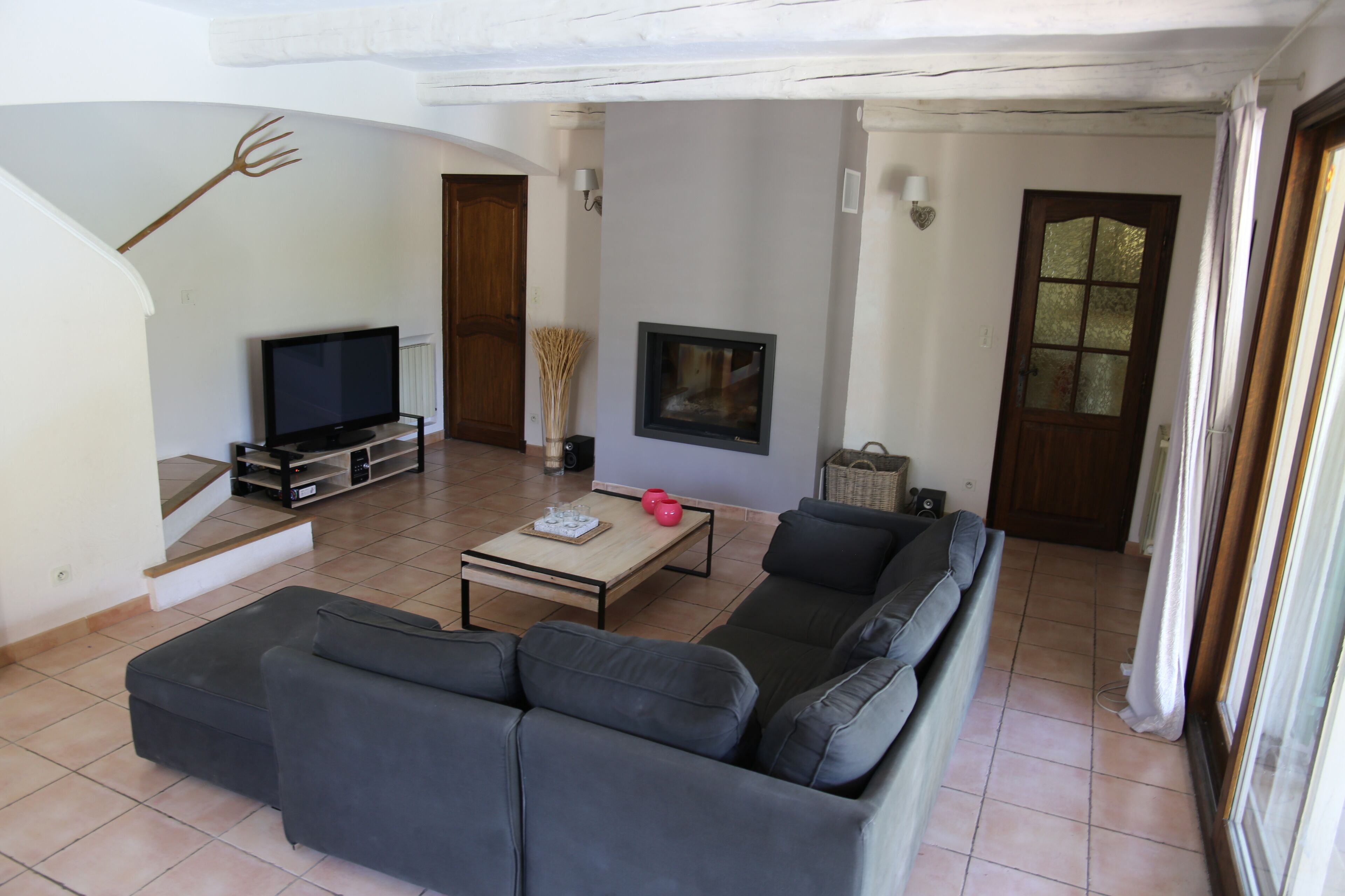 Uma sala de estar com sofá, televisão, lareira e escada.