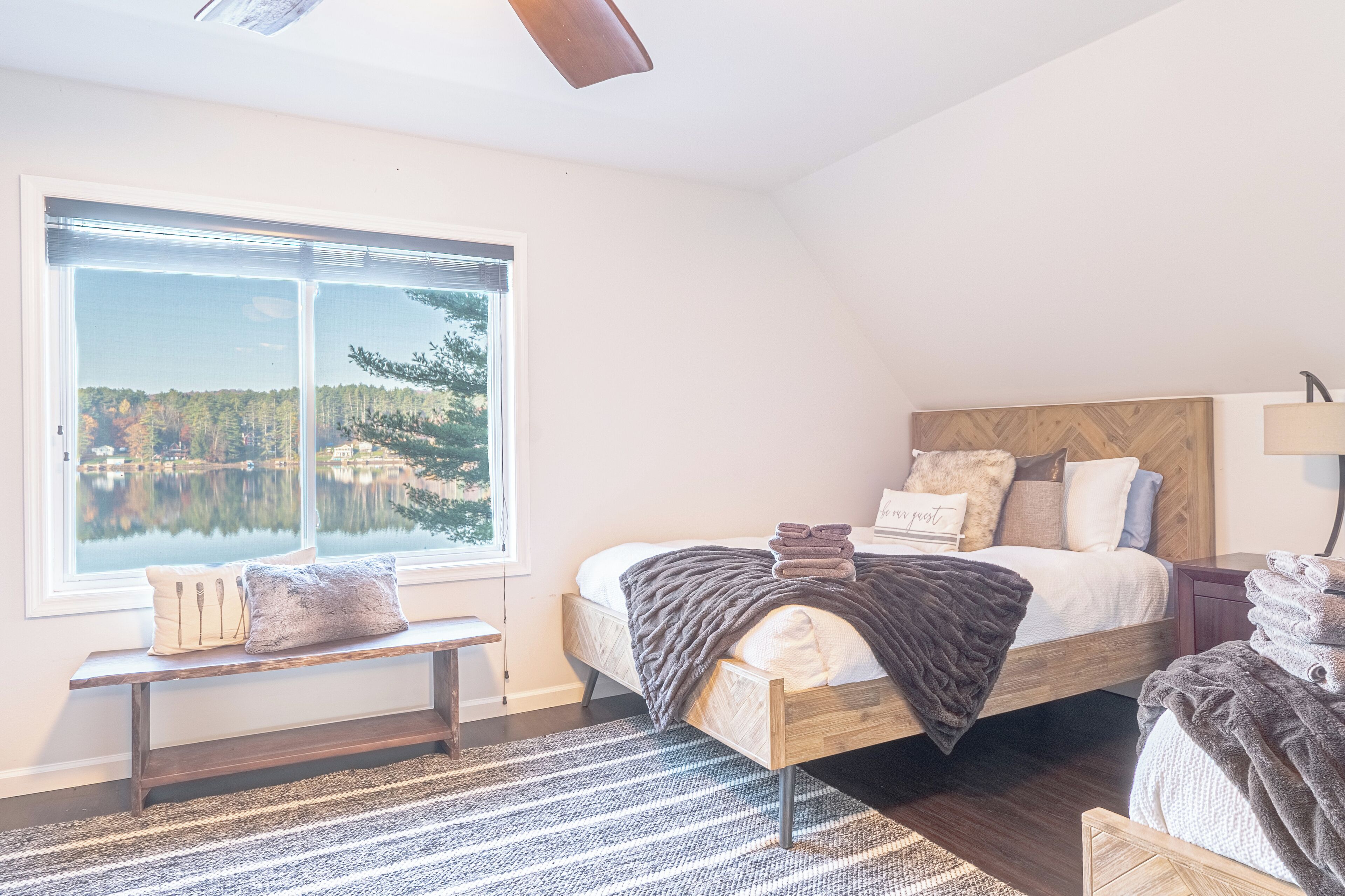 Third-level Queen Bedroom with 3 queen beds, electric fireplace and lake views
