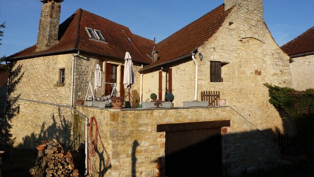A stone building with a tiled roof, a chimney, and a small porch with umbrellas. - Very typical house LOT (Périgord-Quercy) close communal pool + Trade (Lavercantière)