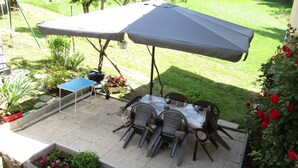 An outdoor patio with a table and chairs, a grill, and a blue table tennis table. - Apartment in house, ALL COMFORT (Prémanon)