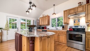 A kitchen with wooden cabinets, a granite countertop, stainless steel appliances, and a large island. - Make lifelong memories at this New England Quintessential Country Getaway (Brookfield)