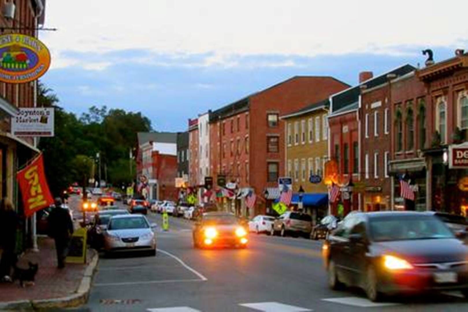 A street scene with buildings, cars, and pedestrians.