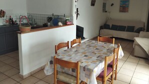 Um espaço compacto com cozinha, área de refeições e sofá.