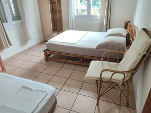 Une pièce comprenant un lit, une chaise et une armoire.