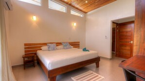 Una camera da letto con un letto in legno, due comodini, una panca, un piccolo tappeto e una porta in legno.