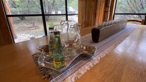 Une table en bois avec une bouteille d’eau, un pichet en verre et un plateau.