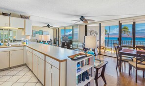 Enjoy ocean views from the kitchen and dining area, featuring a large island and table with ceiling fans.