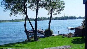A lakeside property with a grassy area, dock, and a small building.