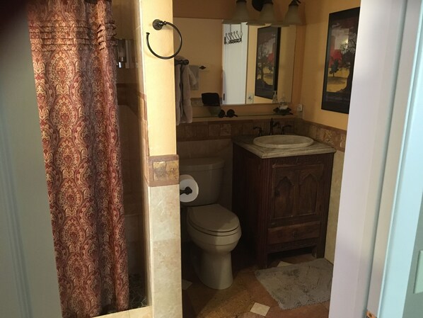 A bathroom with a toilet, sink, and mirror. - View with a room Cathedral Rock too! (Sedona)