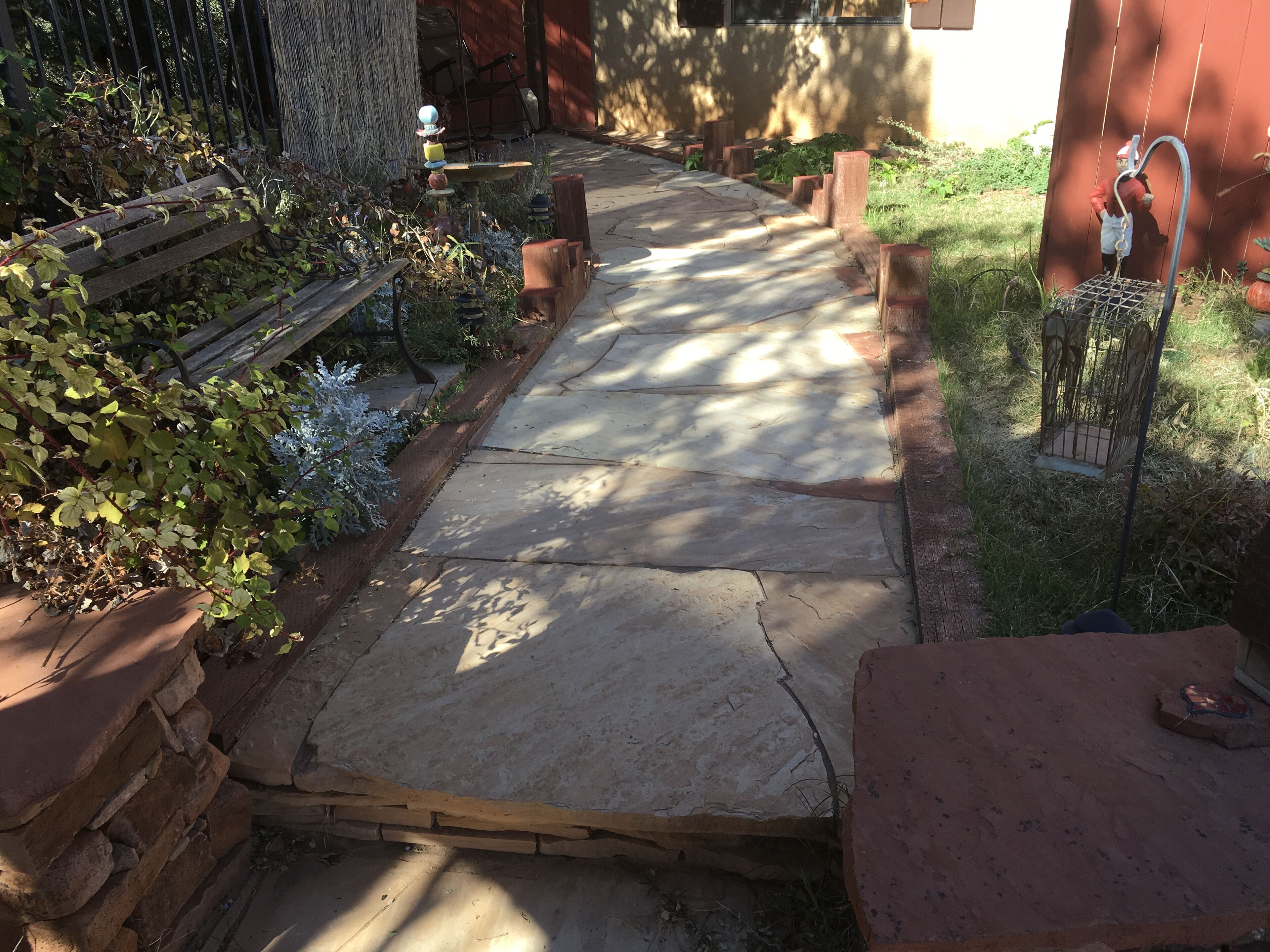 Un chemin de pierres mène à une maison à l’extérieur rouge.