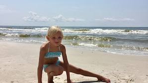 A child on a sandy beach with a heart-shaped arrangement of seashells. - Bayfront Cottage. Private pier! Sunsets! Sunrises! 4 acres! New bike trail. (Gulf shores)