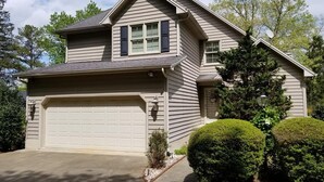 A two-story house with a garage, a small front yard, and a well-maintained lawn. - Beautiful 5 bedroom, 3.5 bath home on a quiet cove on Lake Gaston (Littleton)