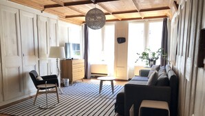 Un salon avec un canapé, des fauteuils, une table basse et un tapis.