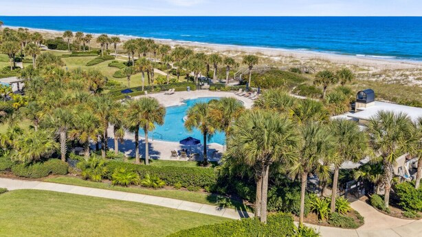 A resort with a central pool, surrounded by palm trees and a beach view. - 1856 - The Coastal Canvas: Serene Beachfront (Fernandina Beach)